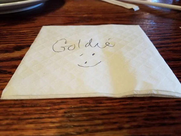 Servilleta con el nombre Goldie y una cara en la mesa —  Fotos de Stock