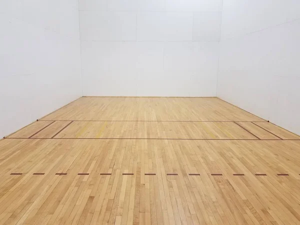 Деревянный пол для ракетбола с белыми стенами — стоковое фото