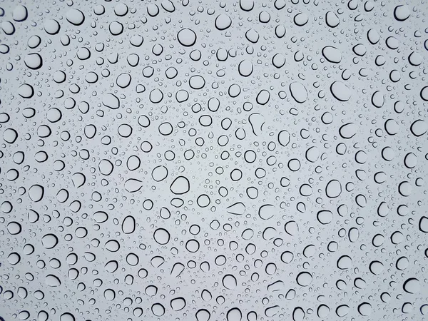 Circular water droplets or drops on glass window from rain — Stock Photo, Image
