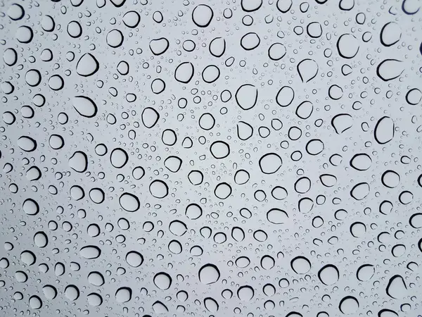 Circular water droplets or drops on glass window from rain — Stock Photo, Image