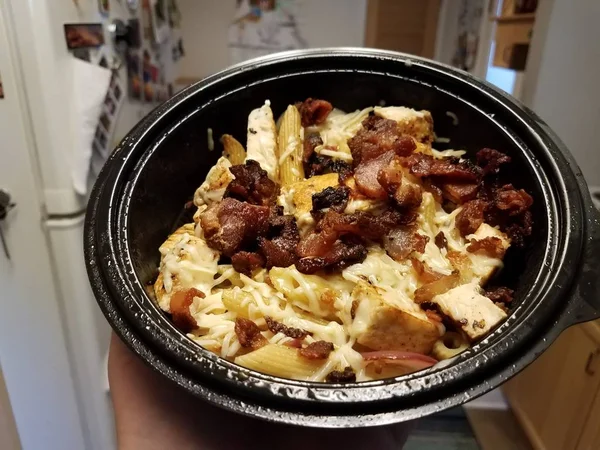 Mão segurando tigela de macarrão com queijo e frango e bacon — Fotografia de Stock