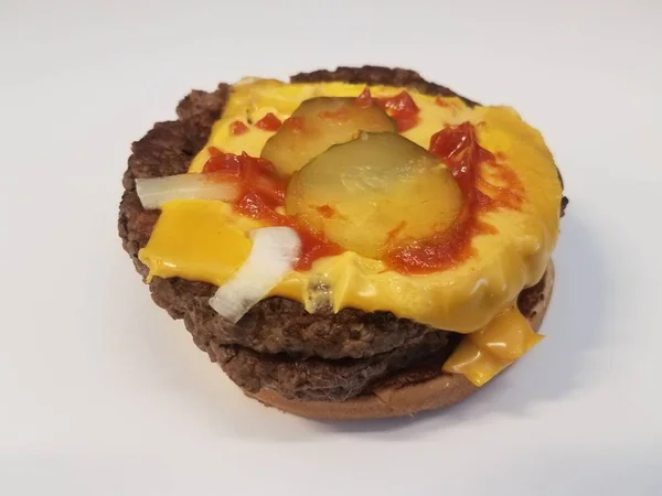 Hambúrguer com queijo e picles e ketchup na superfície branca — Fotografia de Stock