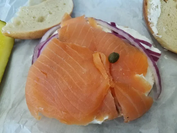 Salmão em bagel com creme de queijo, alcaparras e cebola — Fotografia de Stock