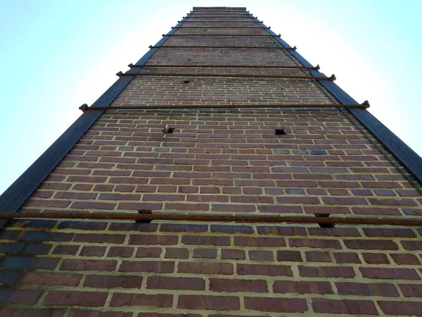Wysoki Czerwony ceglany komin lub murowany z metalowym wsparciem — Zdjęcie stockowe