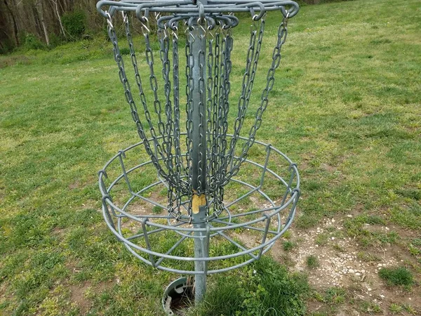 Flying disc golf metal chain cage or basket and green grass — Stock Photo, Image
