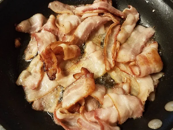 Cozinhar bacon na frigideira ou frigideira no fogão — Fotografia de Stock