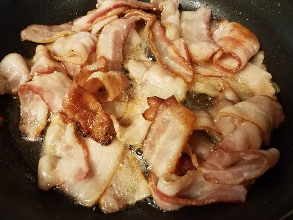 Cozinhar bacon na frigideira ou frigideira no fogão — Fotografia de Stock