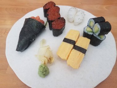 somon yumurta, yumurta ve kalamar ile beyaz plaka üzerinde suşi