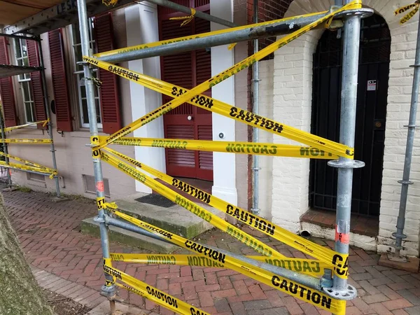 Andamios de construcción con cinta de advertencia amarilla y ladrillos —  Fotos de Stock