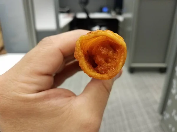 Mão segurando frango frito junk comida no escritório — Fotografia de Stock