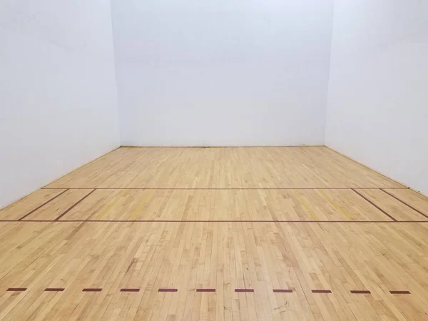 Wooden floor on racketball court with white wall — Stock Photo, Image