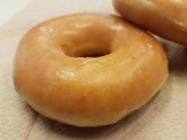 Сладкий глазированный сахарный пончик на бумажном полотенце — стоковое фото