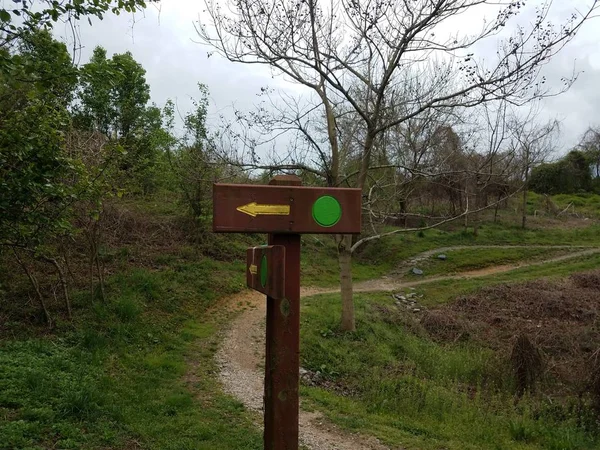 Schild mit grünen Punkten und gelben Pfeilen und Wegweiser — Stockfoto