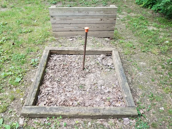 horseshoe pit with metal pole and wood backstop