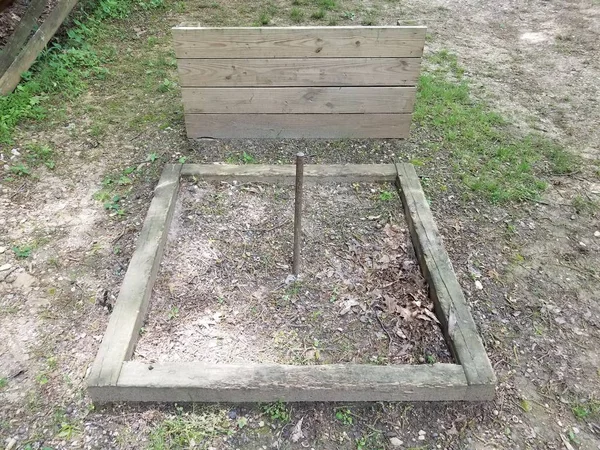 horseshoe pit with metal pole and wood backstop