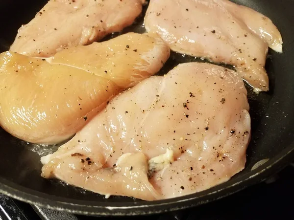 Carne de frango crua cozinhar na frigideira com óleo — Fotografia de Stock