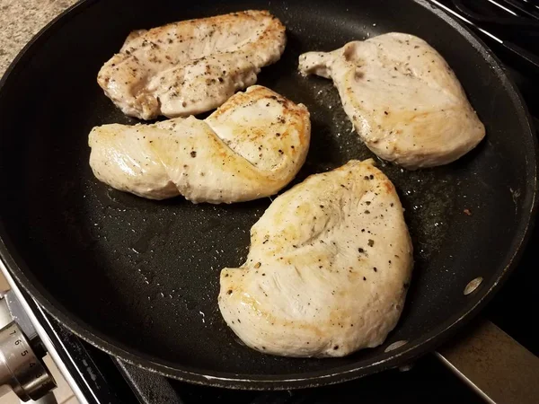 Сырое мясо курицы приготовление в сковороде с маслом — стоковое фото