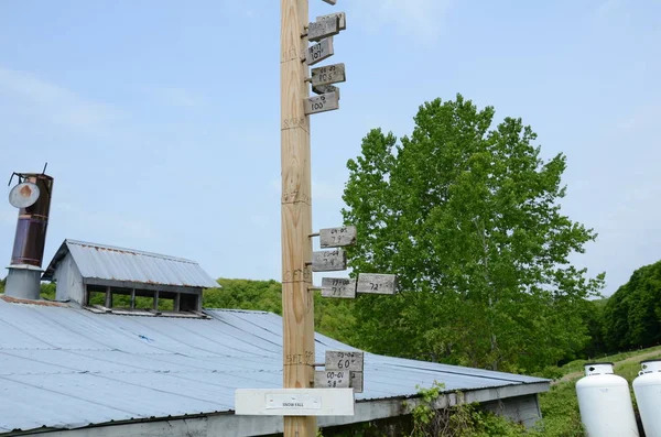 wood pole or stake with snowfall sign and snow depth markings