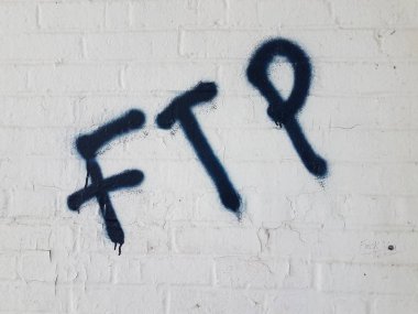 beyaz tuğla duvara boyanmış ftp sprey harfleri