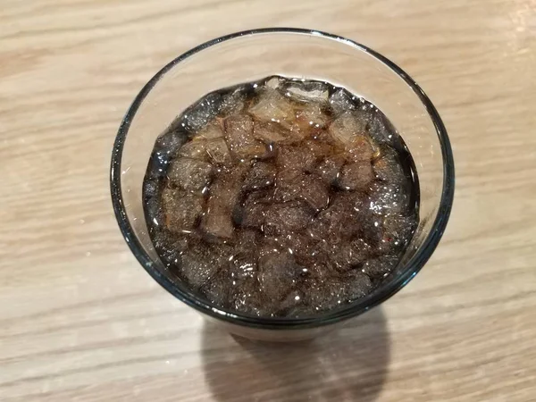 Vaso de soda con hielo sobre mesa marrón —  Fotos de Stock