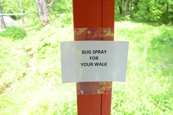 Spray de insectos para su signo de paseo en el poste de madera — Foto de Stock