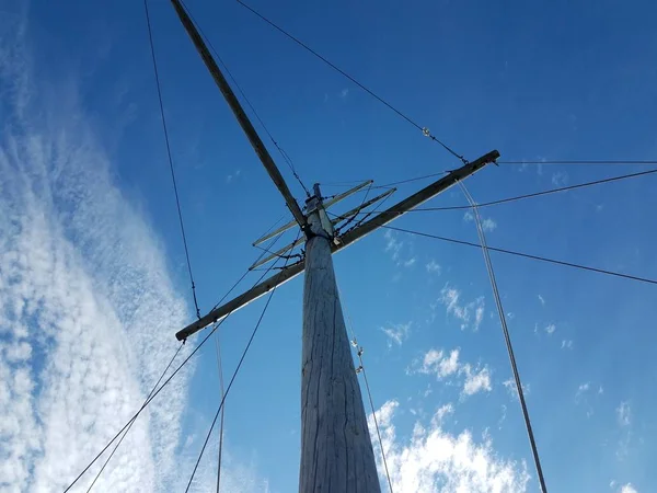 Wood pole boat mast with cables and blue sky — Stock Photo, Image