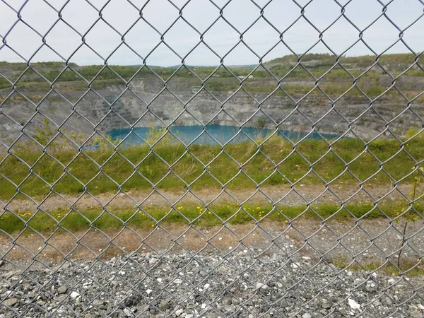 Cerca e água do lago na antiga mina abandonada em Asbesto, Canadá — Fotografia de Stock