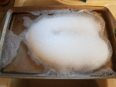 mutfak lavabo sabun ve su ile metal fırın tepsisi