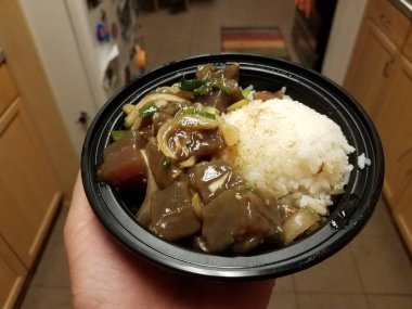 plastik çanak veya kase de ton balığı, pirinç ve soğan tutan el