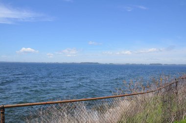 okyanus suyu ve gökyüzü ile metal zincir bağlantı çit