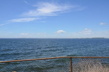 okyanus suyu ve gökyüzü ile metal zincir bağlantı çit