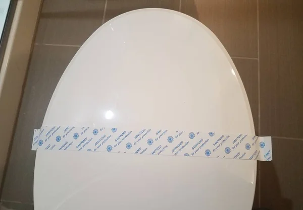 Désinfecté pour votre bande de protection sur les toilettes blanches dans la salle de bain — Photo
