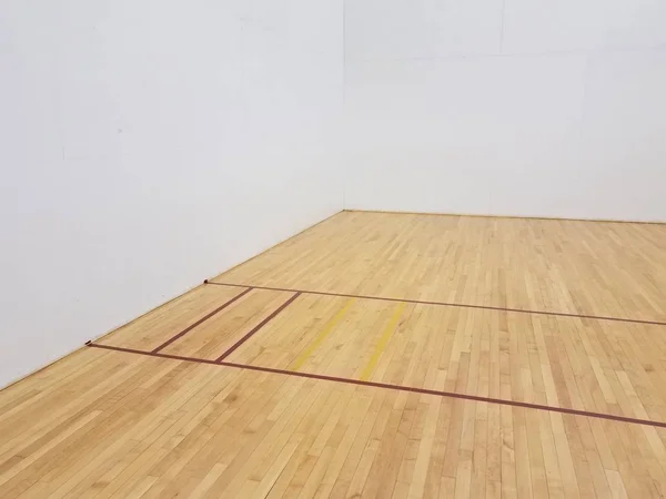 Красная лента на деревянном полу с белыми стенами на корте для ракетбола — стоковое фото
