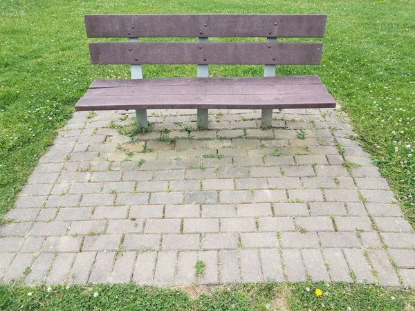 Trä parkbänk och tegel och grönt gräs — Stockfoto