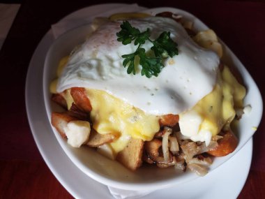 Beyaz plaka üzerinde patates ve yumurta ve sarı sos