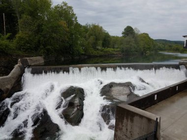 şelale veya Rapids ve kayalar ve bina