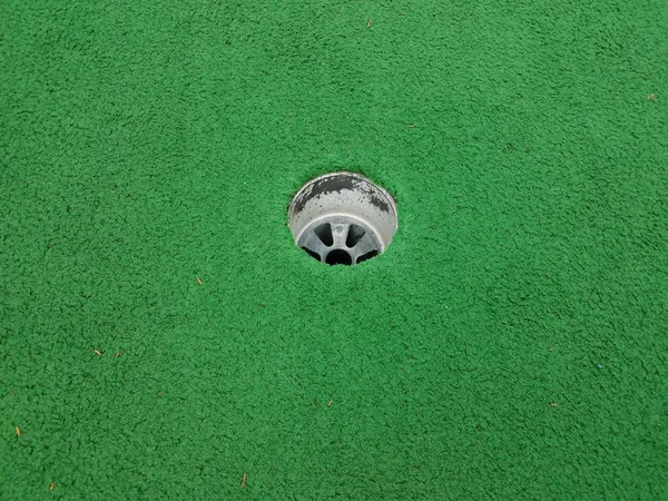 Buraco no campo de golfe em miniatura com grama artificial verde — Fotografia de Stock