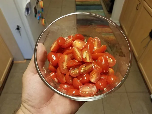 Рука тримає скляну тару нарізаного помідора — стокове фото
