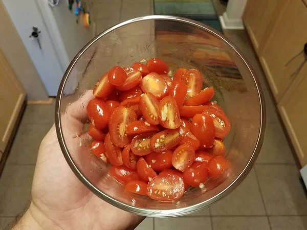 Hand holding glass container of sliced tomato — Stock Photo, Image