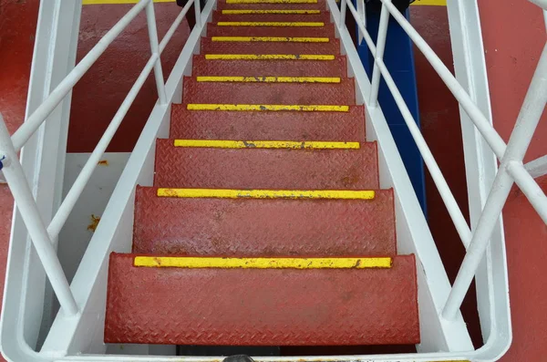 red metal steps or stairs with railing on ship