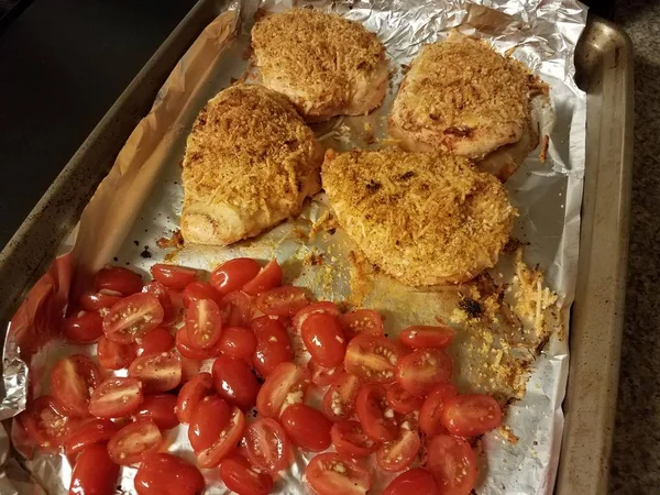 焼き上げシートに鶏の胸肉とトマトを焼いた — ストック写真