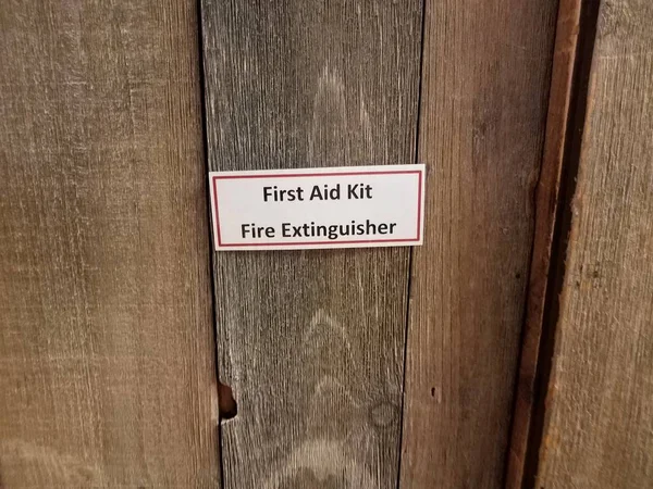 EHBO kit brandblusser teken op houten deur — Stockfoto