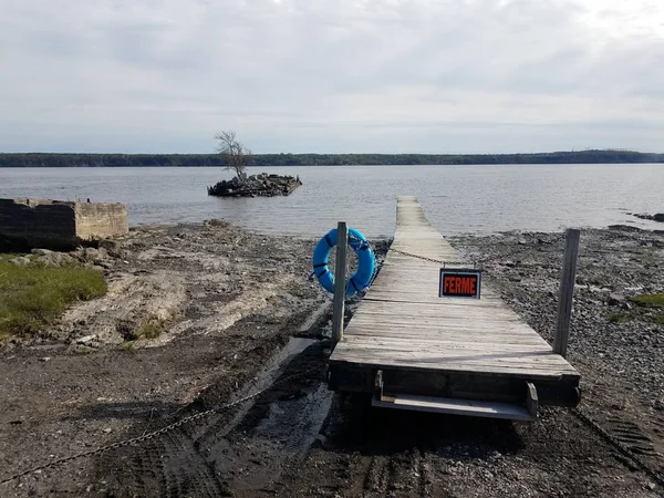 Wooden boardwalk with closed sign in French and river in Canada — Stock Photo, Image