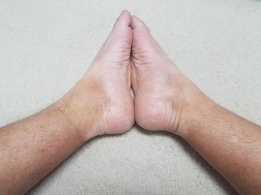 ayak ve beyaz halı üzerinde renksiz kırmızı deri