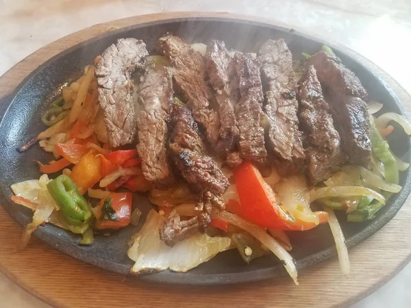 Plato caliente de tiras de ternera y pimientos y humo — Foto de Stock