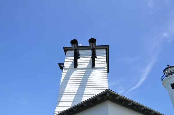 White building with black pipes or tubes and seagull — Stock Photo, Image