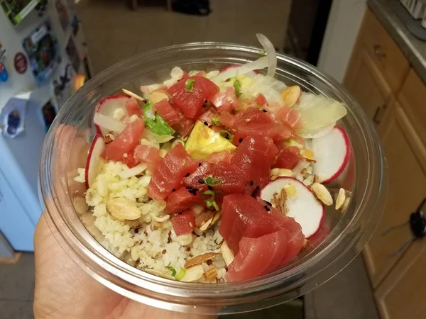 Hand holding bowl of raw tuna, avocado, and rice — Stock Photo, Image