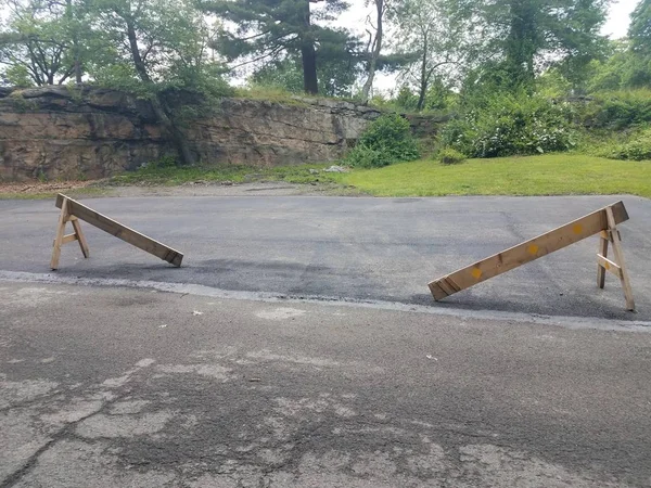 Bloqueio de madeira quebrado ou barricada no asfalto — Fotografia de Stock