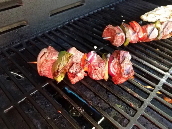 Beef kebob with onions and peppers on a stick on a grill with chicken — Stock Photo, Image