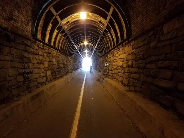 Tunnel with stone wall and light at end of tunnel — Photo